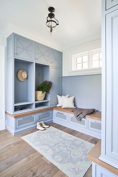 a room with some blue cabinets and a white rug on the wooden floor next to it