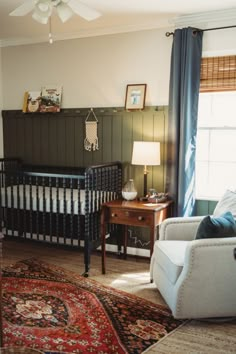 a baby's room with a crib, chair and rug in the corner