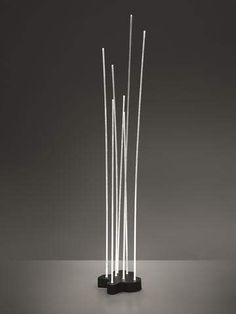 a black and white sculpture with four sticks sticking out of it's sides on a table