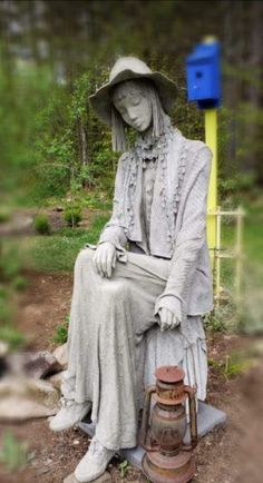 a statue of a woman sitting next to a blue mailbox