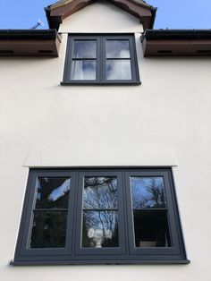 a white house with black windows and brown roof