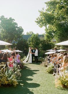 a bride and groom standing in front of an outdoor ceremony