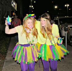 two young women dressed in colorful costumes posing for the camera