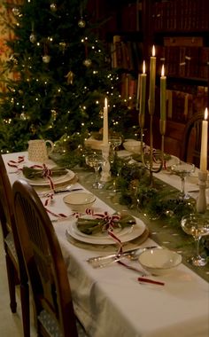 a christmas table setting with candles and plates