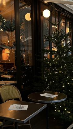 two tables and chairs in front of a christmas tree