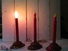 three red candles sitting on top of a table