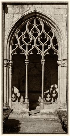 black and white photograph of an arch in a building with iron work on the doors