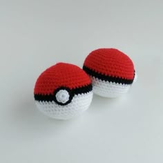 two crocheted pokeballs sitting side by side