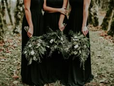 three bridesmaids in long black dresses with greenery wreaths