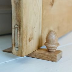 a small wooden object sitting on top of a white floor next to a door handle