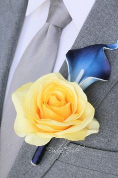 a boutonniere with a yellow rose on it's lapel pin