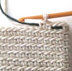 a crochet basket is shown with a knitting needle