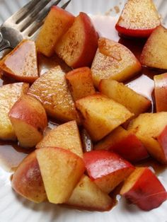 a white plate topped with sliced apples next to a fork