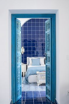 an open door leading to a bedroom with blue tile