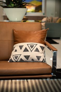 a brown leather chair with a pillow on it