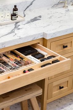 an open drawer in the middle of a counter with cosmetics and other items inside it