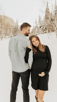 a man and woman are standing in the snow