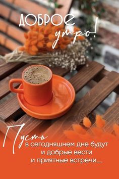 a cup of coffee sitting on top of a wooden table next to an orange saucer