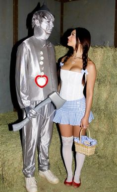 a woman standing next to a man in a costume