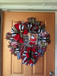 a red and black christmas wreath on a door