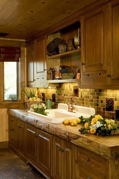 a kitchen with wooden cabinets and counter tops has flowers on the sink, along with other items