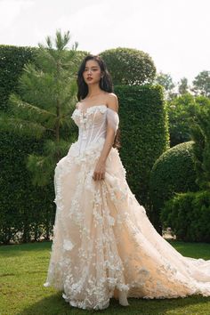 a woman in a wedding dress standing on the grass