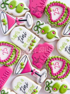 some decorated cookies are on a white plate and have pink, green and white frosting