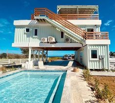 a house with a swimming pool in front of it and a car parked under the roof