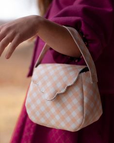 a close up of a person holding a purse