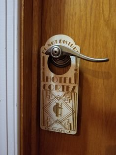 a hotel room door handle on a wooden door