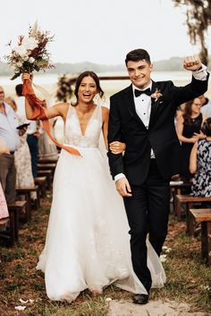 a bride and groom walking down the aisle after their wedding ceremony at an outdoor venue