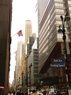 the street is crowded with cars and people walking around in front of tall skyscrapers