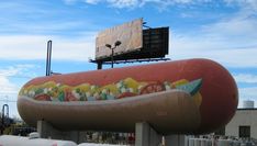 a giant hot dog with toppings on it's side