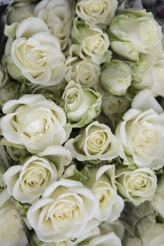 a bunch of white roses that are in the middle of some kind of flower arrangement