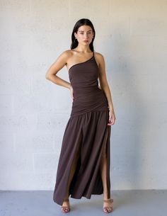 Effortless and edgy, the Lena Maxi Dress is a beautiful asymmetrical style with gathered detailing through the bodice. The one-shoulder dress features side cut-outs, an alluring side leg split and thin rouleau straps that cross the back, with the flowy maxi-length skirt falling from a dropped waist. Drop Waist Maxi Dress, Asymmetrical Style, Leg Split, Side Cuts, Fall Skirts, Drop Waist, Cut Outs, Cognac, One Shoulder Dress