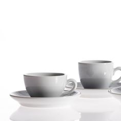 three cups and saucers sitting on top of each other in front of a white background