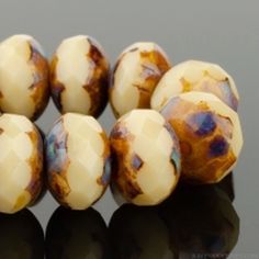 six white and brown beads sitting on top of a table