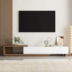 a living room with a large flat screen tv mounted on the wall above a white entertainment center