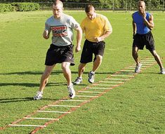 three men are running on a track in the grass