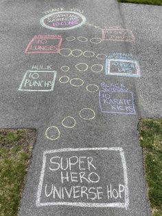 chalk drawings on the sidewalk that says super hero universe hop and have been written in different languages