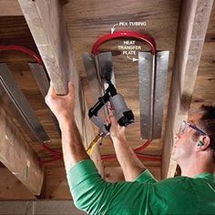 a man is working on the ceiling in his house with tools and wires attached to it