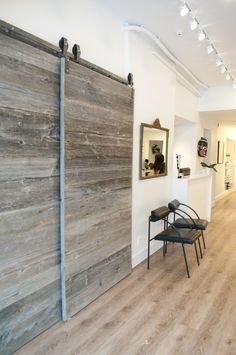 an empty room with wooden doors and chairs