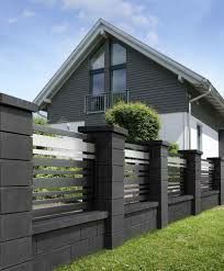 a house with a fence in front of it and grass on the ground next to it