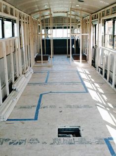 the inside of a building being built with blue tape on the floor and windows in it