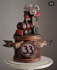 there is a cake that looks like a train on top of a stand with the number 33 on it