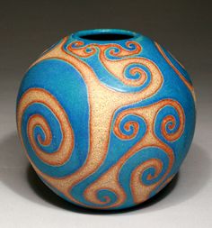 a blue and orange vase sitting on top of a table