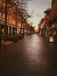 an empty street with people walking down it