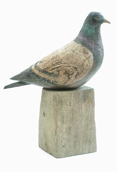 a bird sitting on top of a wooden block