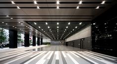 an empty building with lights on the ceiling and striped flooring in front of it