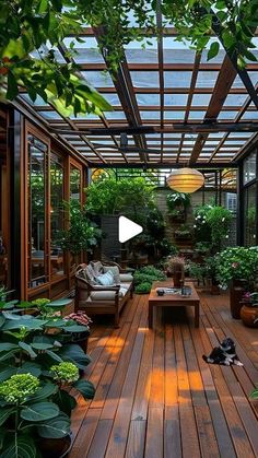 a wooden deck with lots of potted plants on it and a couch in the middle